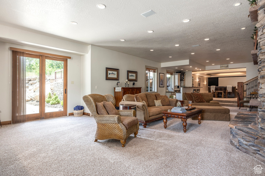 Carpeted living room featuring recessed lighting and a textured ceiling