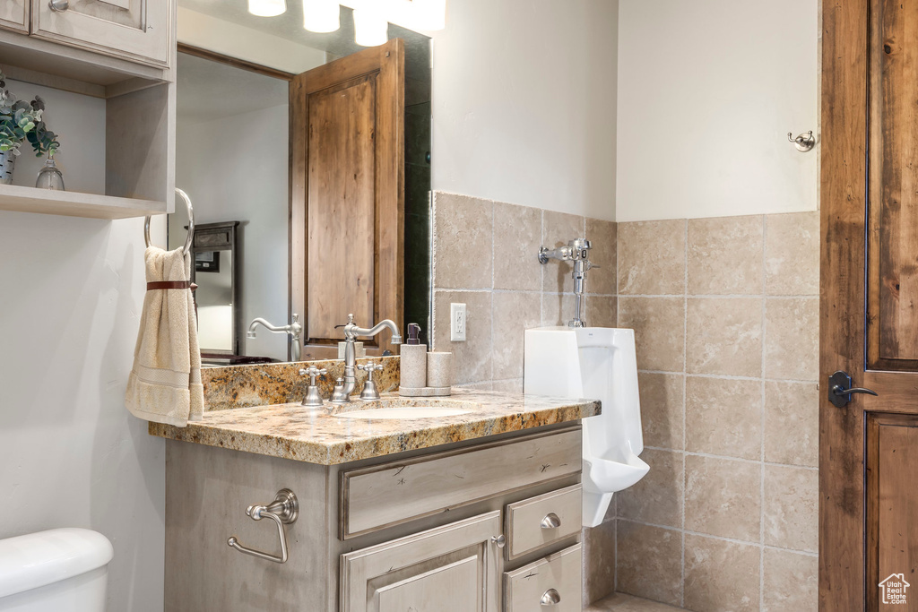 Bathroom featuring vanity and tile walls