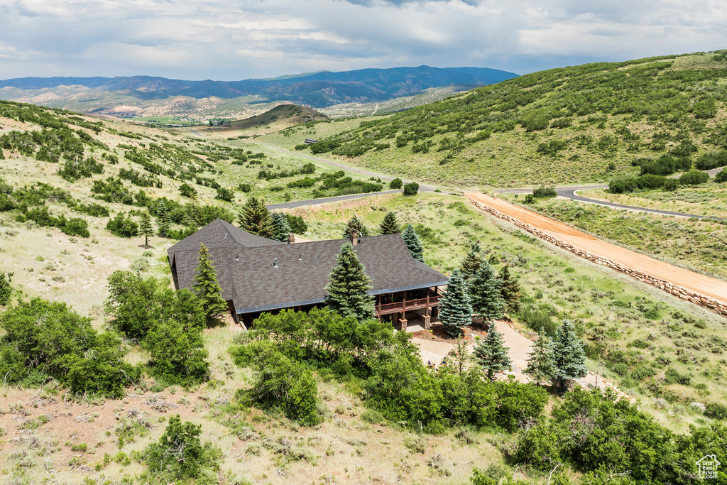 Aerial view of property and surrounding area featuring a mountainous background