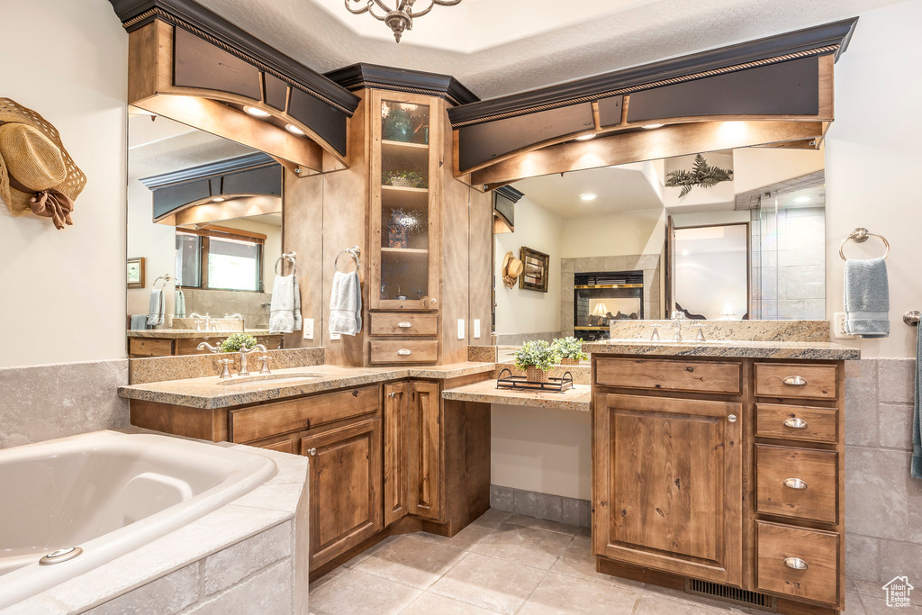Bathroom featuring a garden tub, two vanities, and tile patterned floors