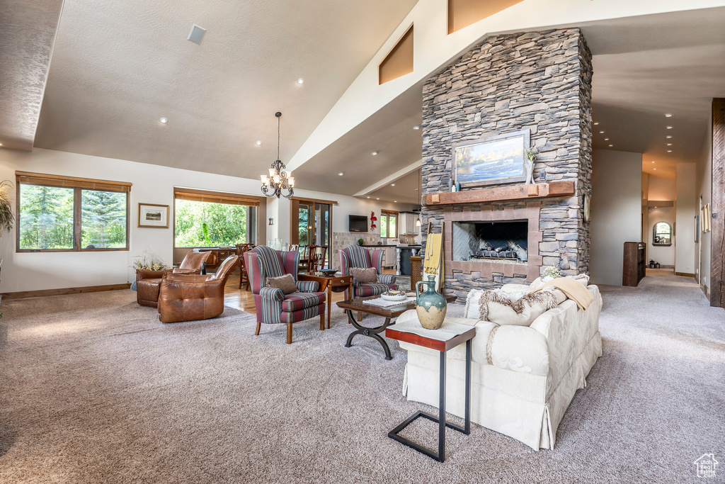 Living area featuring carpet, recessed lighting, a fireplace, a chandelier, and high vaulted ceiling