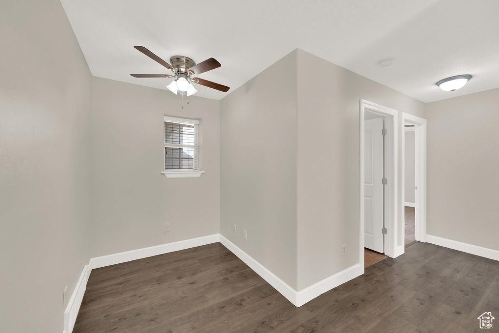 Spare room with a ceiling fan and dark wood-style floors