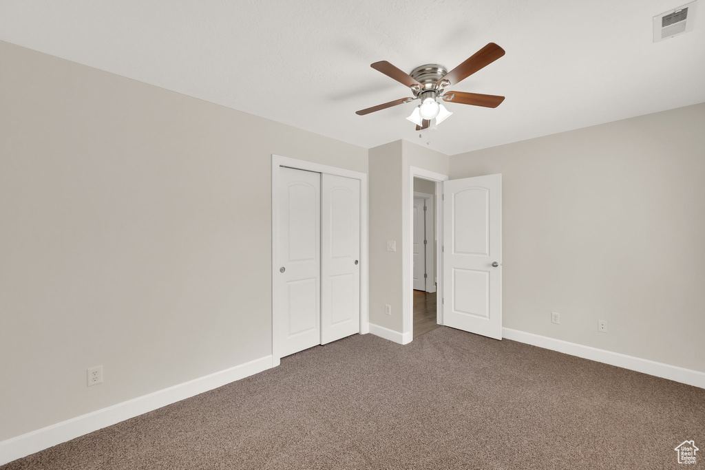 Unfurnished bedroom featuring carpet flooring, a closet, and ceiling fan