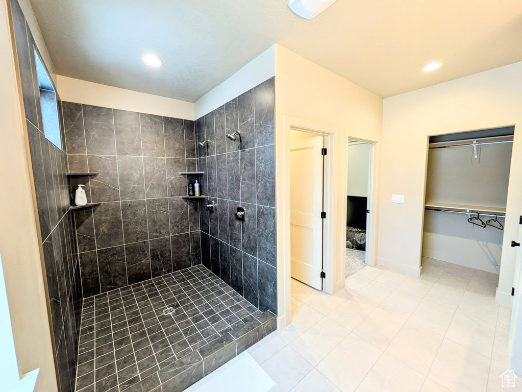 Bathroom featuring tiled shower, tile patterned floors, recessed lighting, and a spacious closet