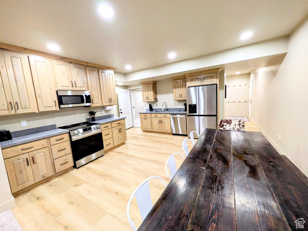 Kitchen featuring stainless steel appliances, light brown cabinets, light wood finished floors, and recessed lighting