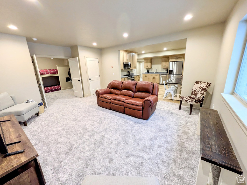 Living area with recessed lighting and light carpet