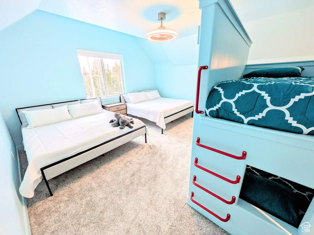 Carpeted bedroom with lofted ceiling