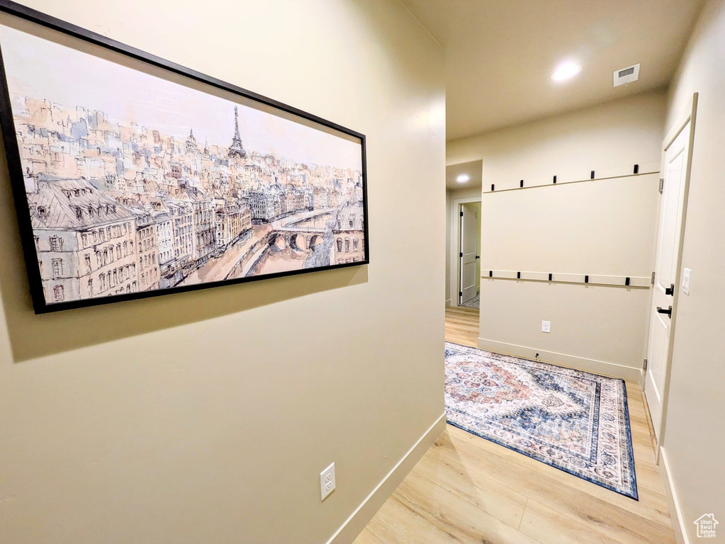 Corridor with wood finished floors and recessed lighting