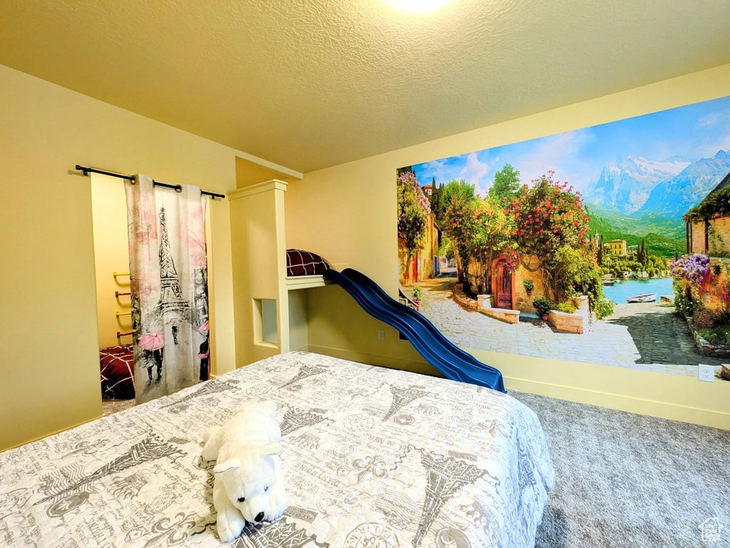Carpeted bedroom with a mountain view and a textured ceiling
