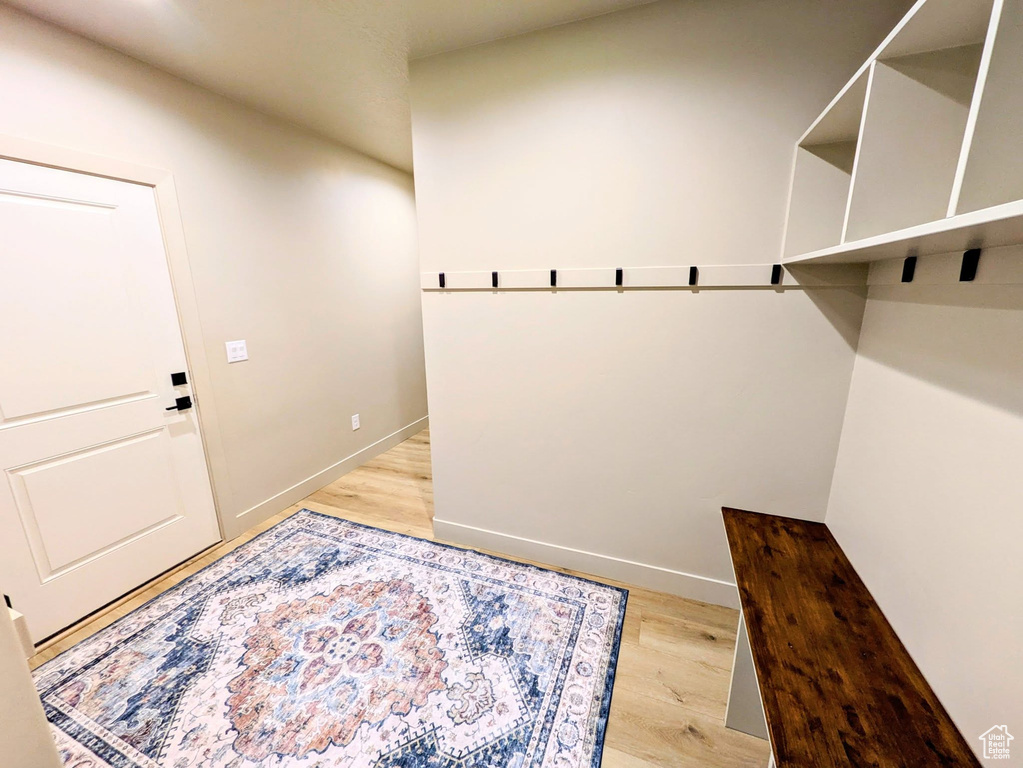 Mudroom featuring light wood-style flooring and baseboards