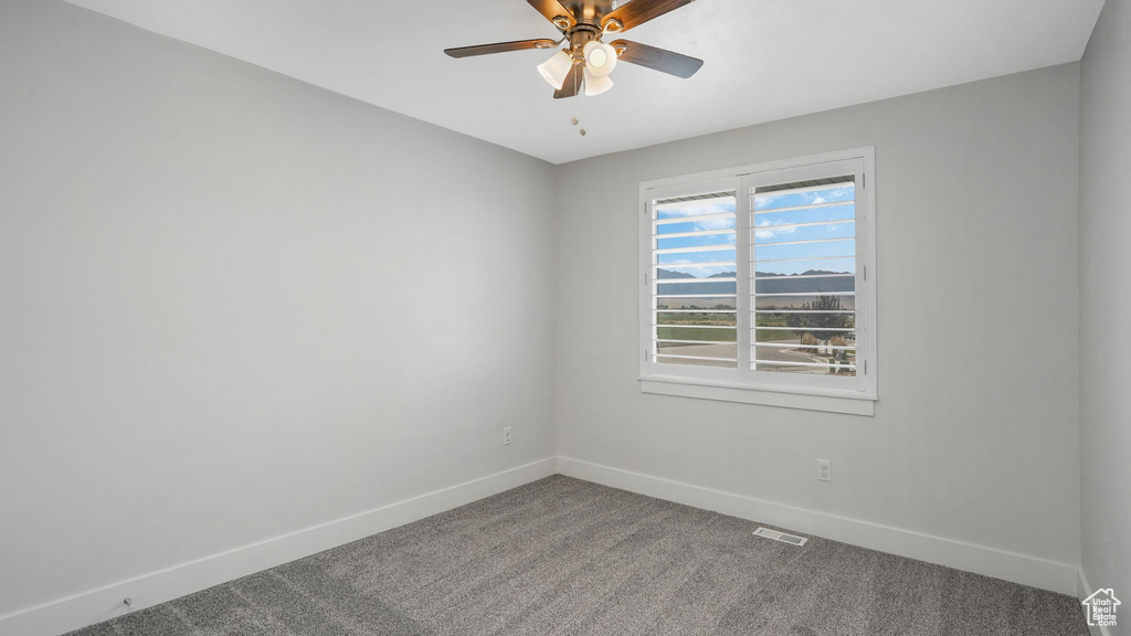 Spare room featuring carpet flooring and ceiling fan