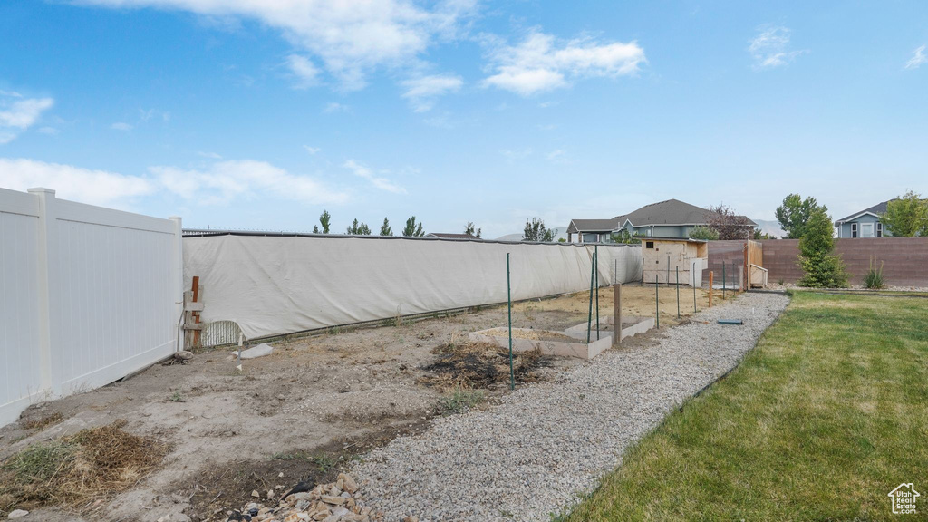 Fenced backyard featuring a vegetable garden