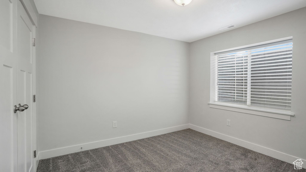 Carpeted empty room with baseboards