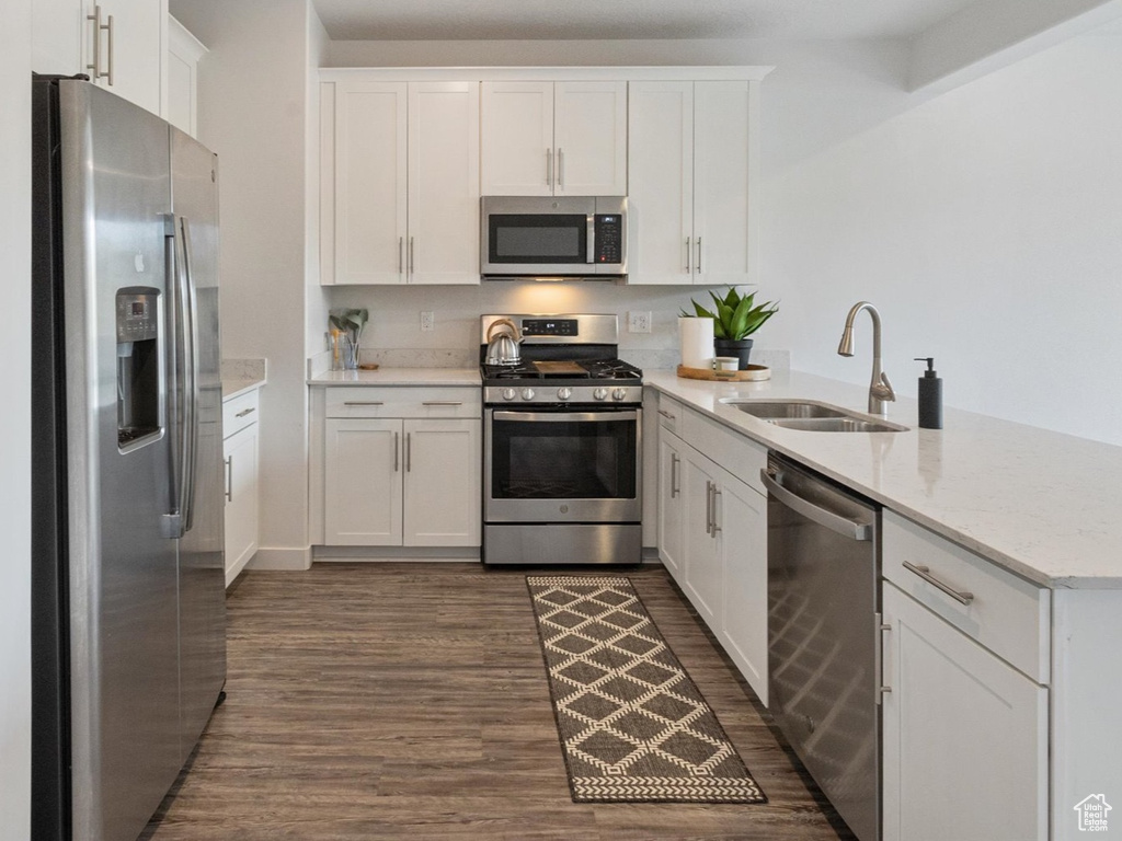 Kitchen featuring stainless steel appliances, a peninsula, white cabinets, and recessed lighting