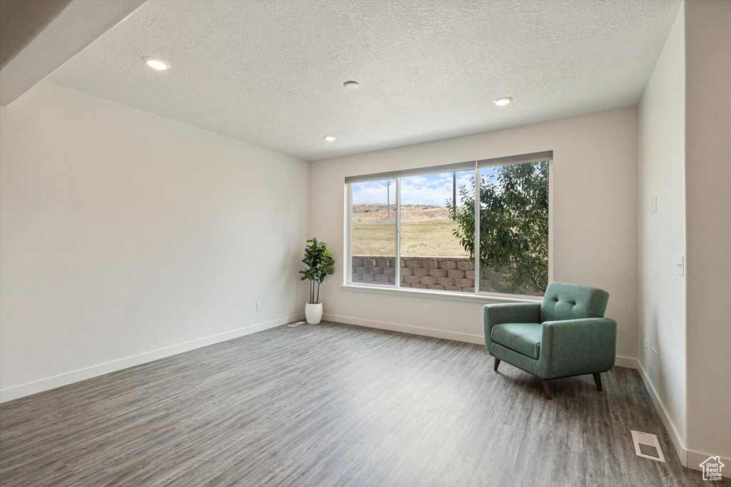 Unfurnished room with wood finished floors, a textured ceiling, and recessed lighting