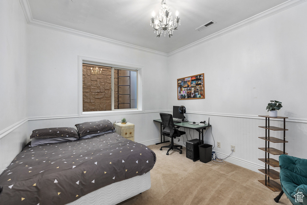 Carpeted bedroom with a chandelier, ornamental molding, an office area, and a wainscoted wall