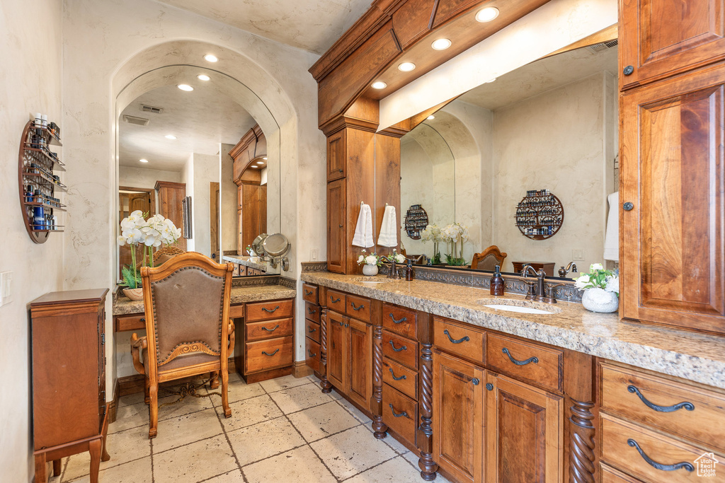 Bathroom featuring recessed lighting, vanity, and stone tile floors