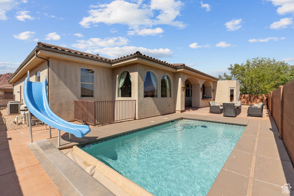 Back of property featuring an outdoor living space, a patio area, a fenced backyard, and stucco siding