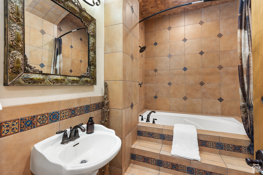 Bathroom with tile walls and tiled shower / bath