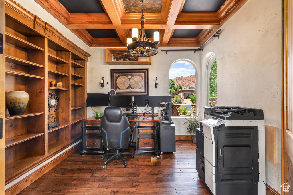 Office space with a chandelier, dark wood-style flooring, beam ceiling, crown molding, and coffered ceiling