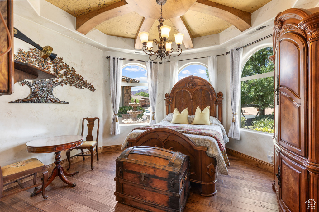 Bedroom featuring a chandelier, wood-type flooring, and beam ceiling