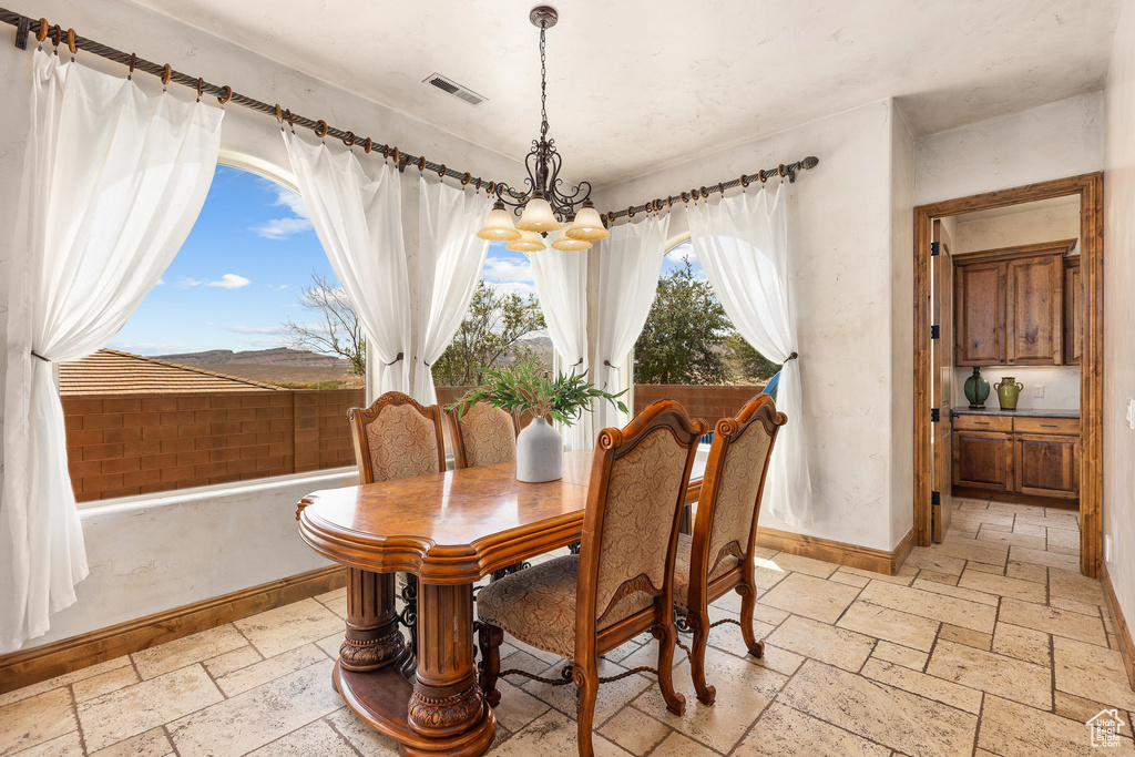 Dining room featuring a chandelier and stone tile floors