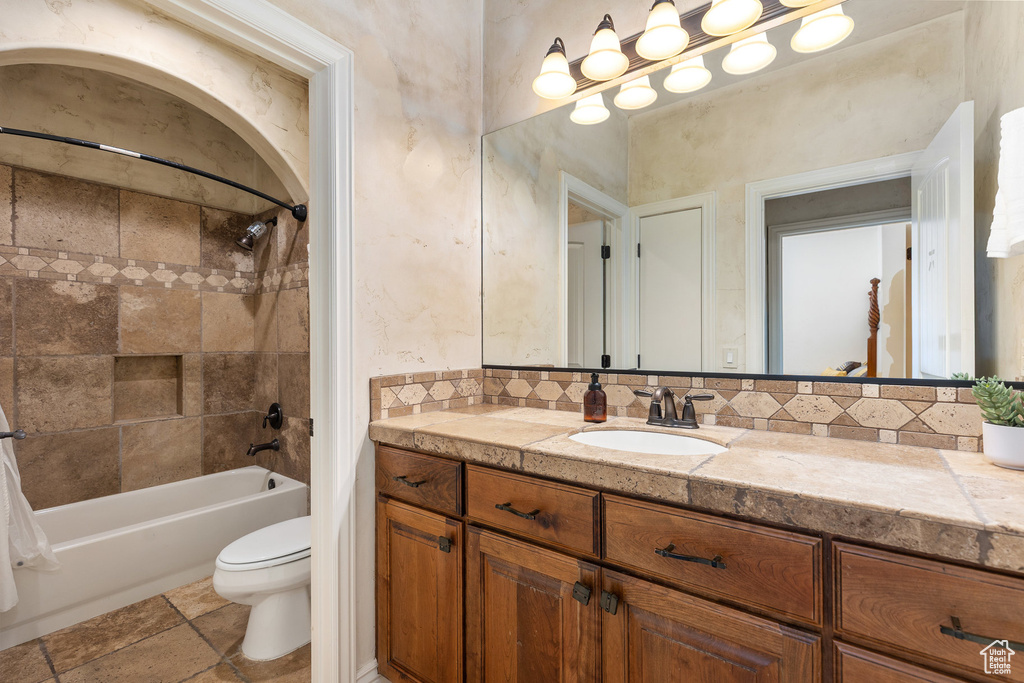 Bathroom featuring vanity, bathing tub / shower combination, and tasteful backsplash
