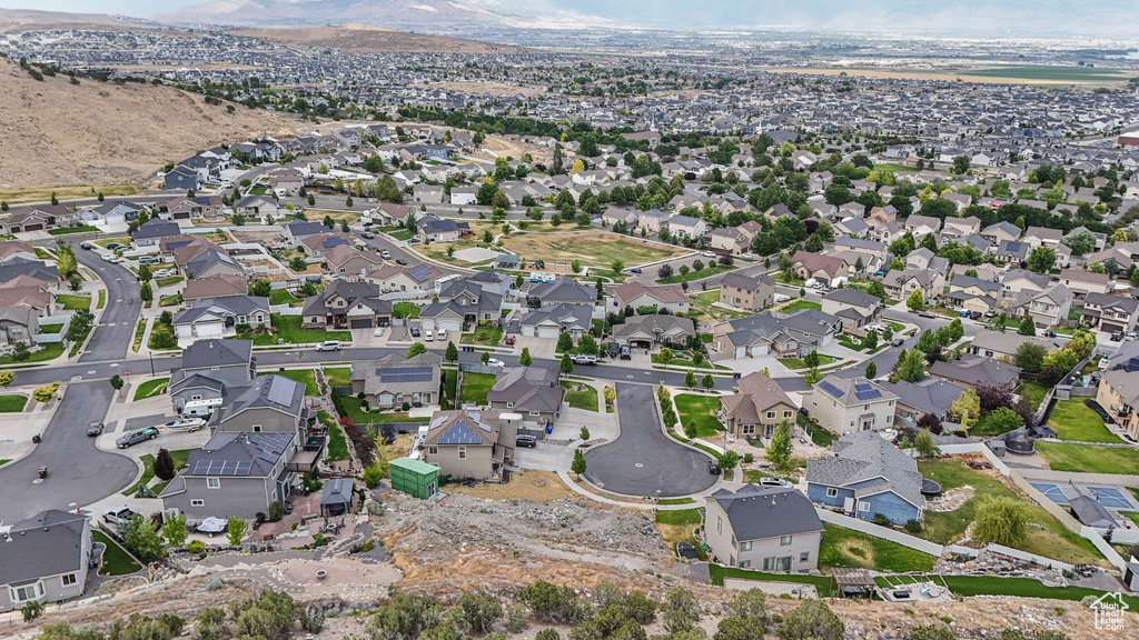 Aerial view of property and surrounding area with nearby suburban area and a mountain backdrop