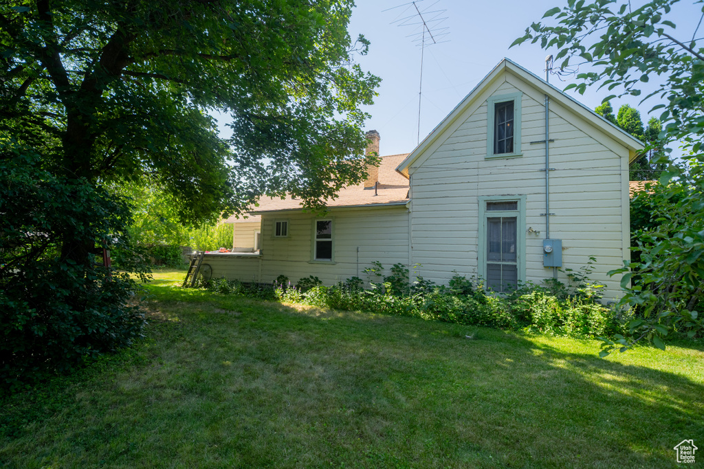 Back of house with a lawn and a chimney