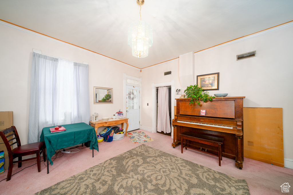 Living area with carpet floors, a chandelier, and crown molding