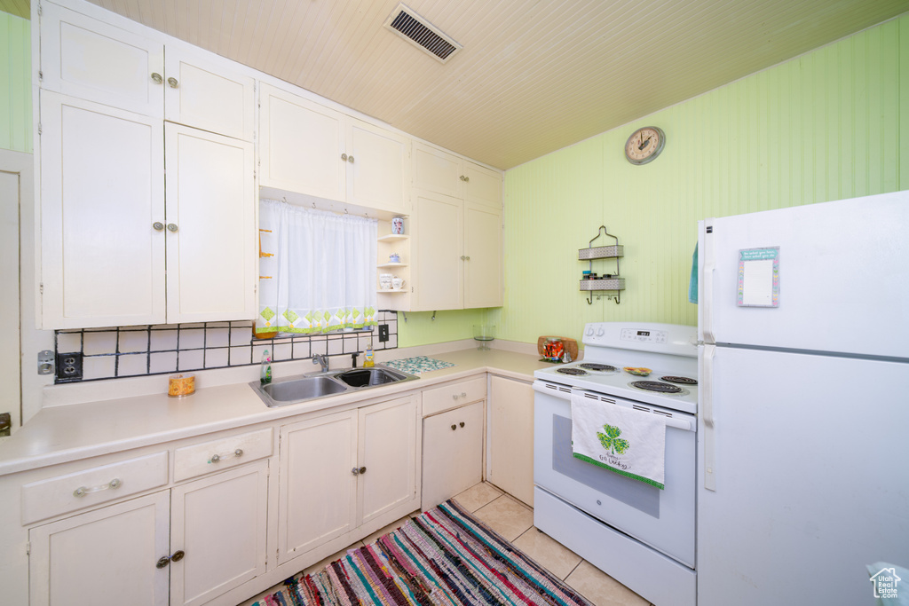 Kitchen with white appliances, open shelves, white cabinetry, and light countertops