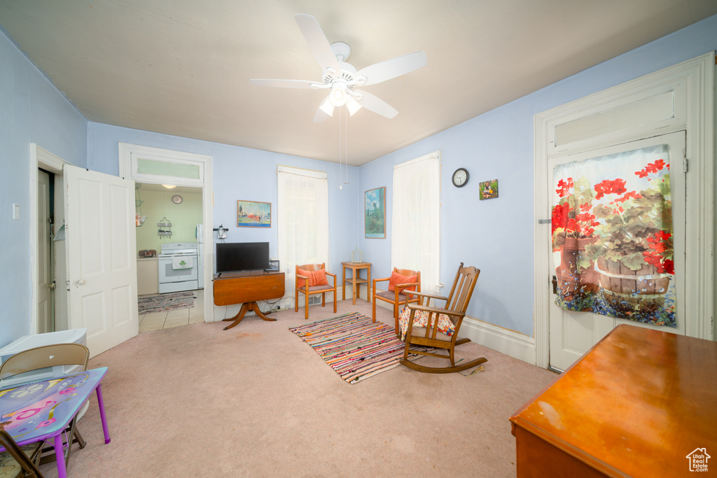 Sitting room with an office area, ceiling fan, and carpet flooring