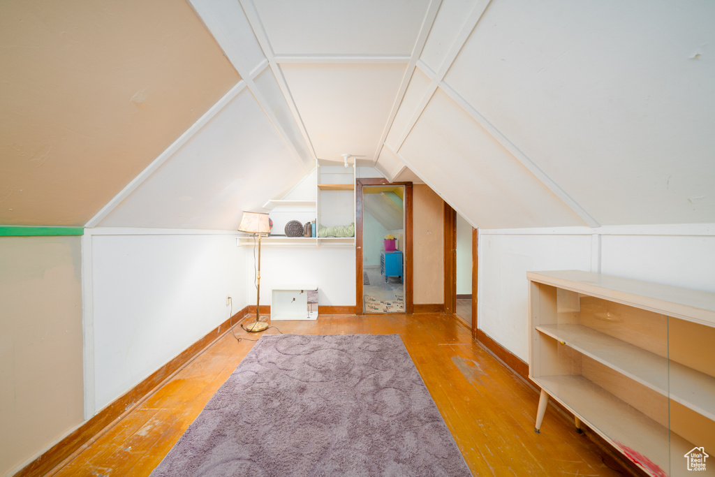 Bonus room with wood-type flooring and vaulted ceiling