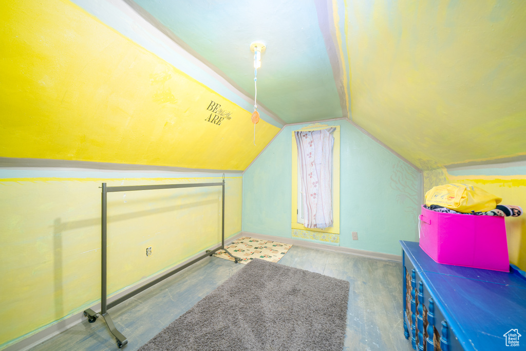 Additional living space with vaulted ceiling and baseboards