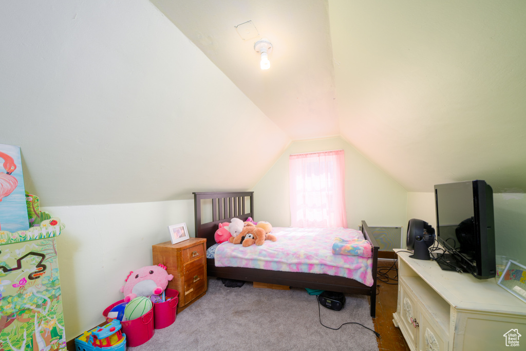 Bedroom with vaulted ceiling and carpet flooring