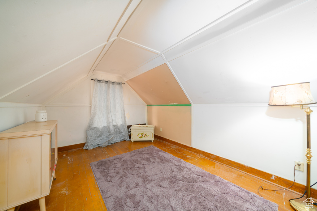 Additional living space with hardwood / wood-style floors and vaulted ceiling