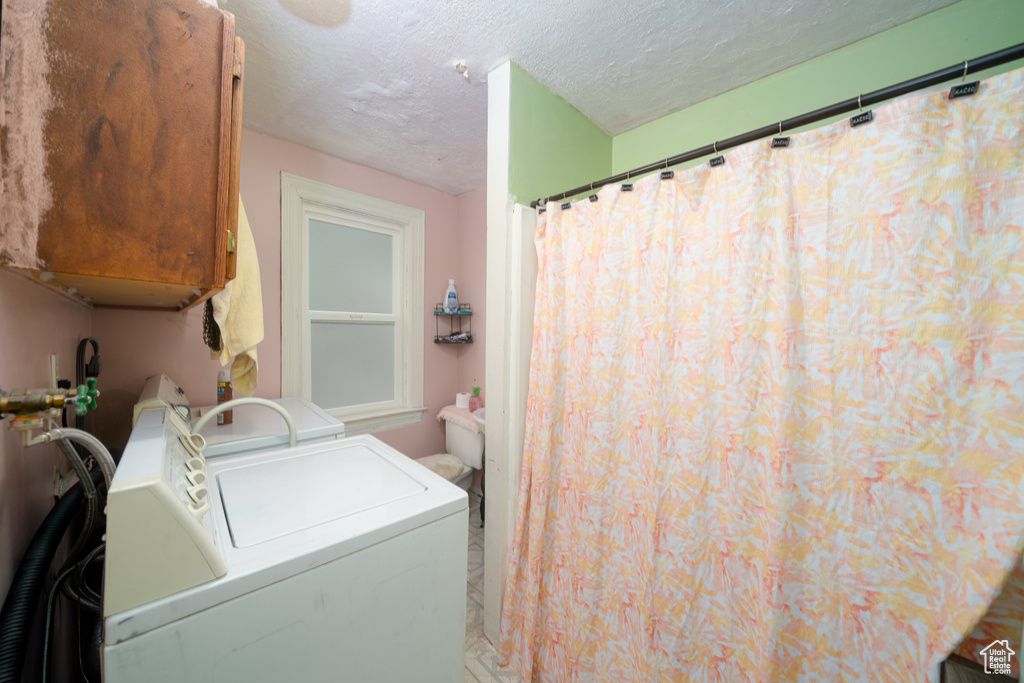 Laundry area featuring washing machine and dryer and a textured ceiling