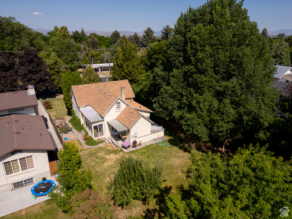 Aerial view of property and surrounding area with a forest