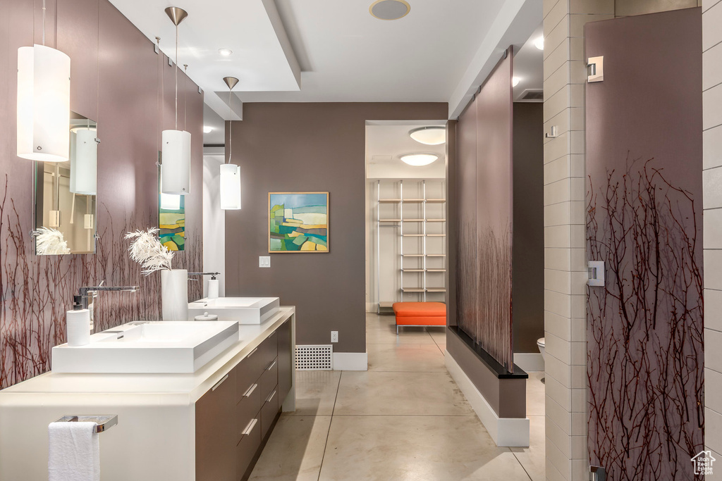 Bathroom with double vanity and concrete flooring