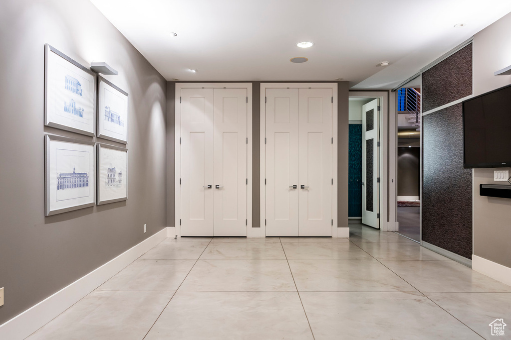 Unfurnished bedroom with multiple closets and light tile patterned floors