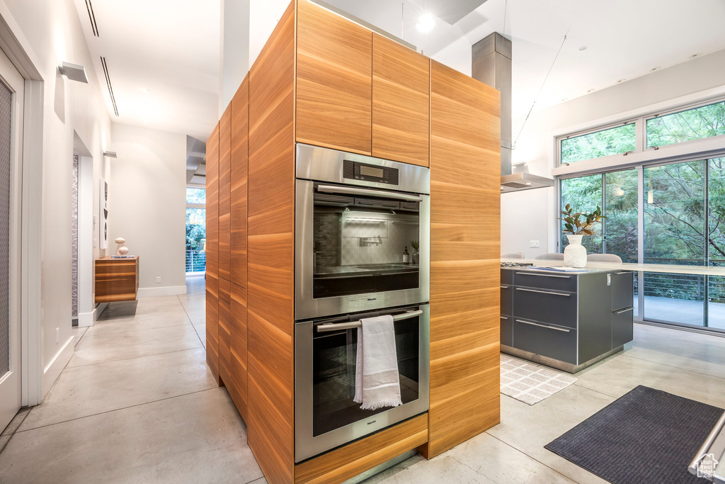 Kitchen featuring double oven, modern cabinets, and healthy amount of natural light