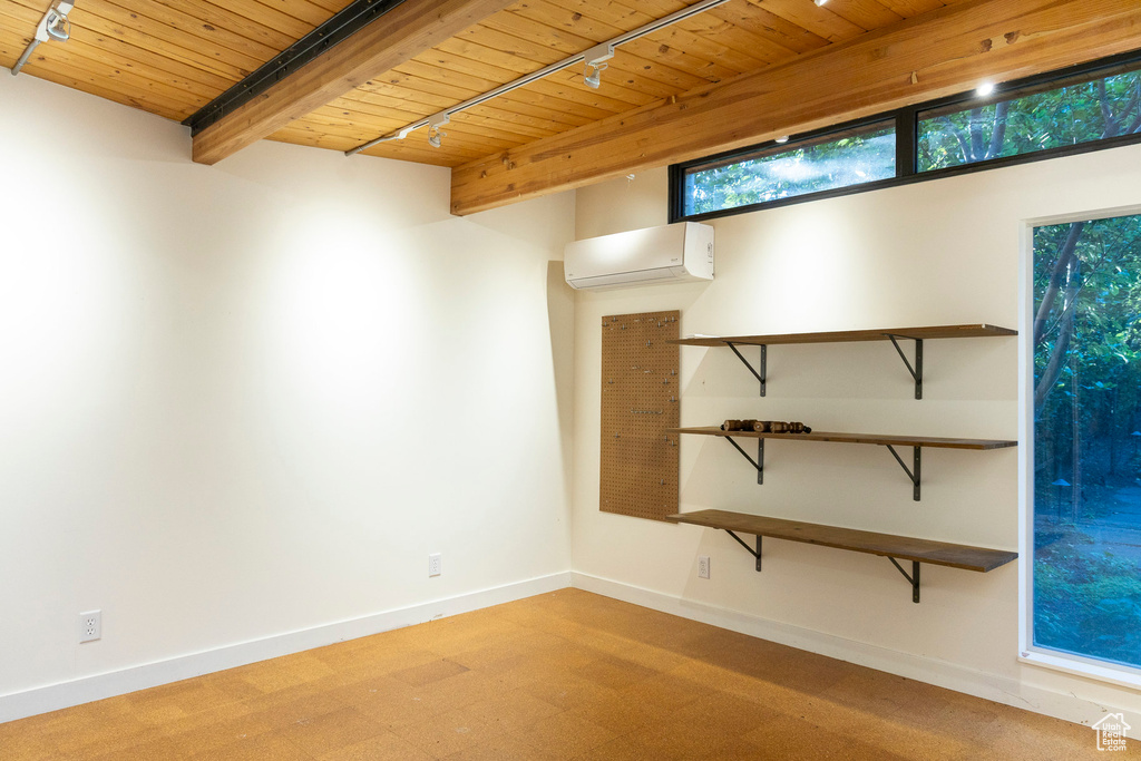 Spare room with a wall unit AC, a wooden ceiling with exposed beams, and rail lighting