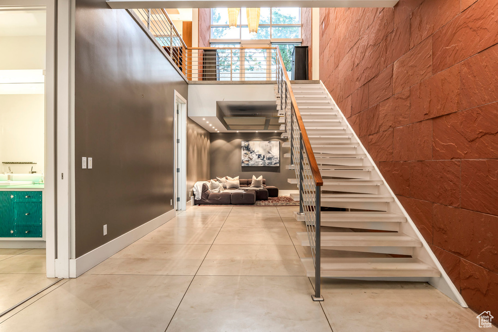 Stairway with a towering ceiling and tile patterned floors