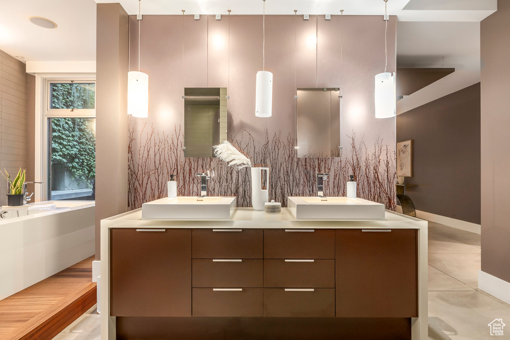 Bathroom featuring double vanity, decorative backsplash, tile patterned flooring, and a garden tub