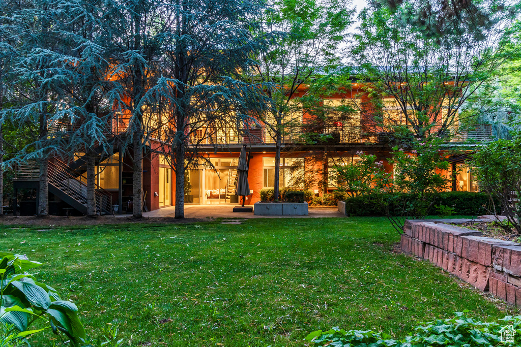 Back of house with a lawn, stairs, and a patio