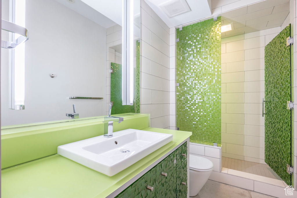 Bathroom featuring vanity, a shower stall, and tile patterned flooring