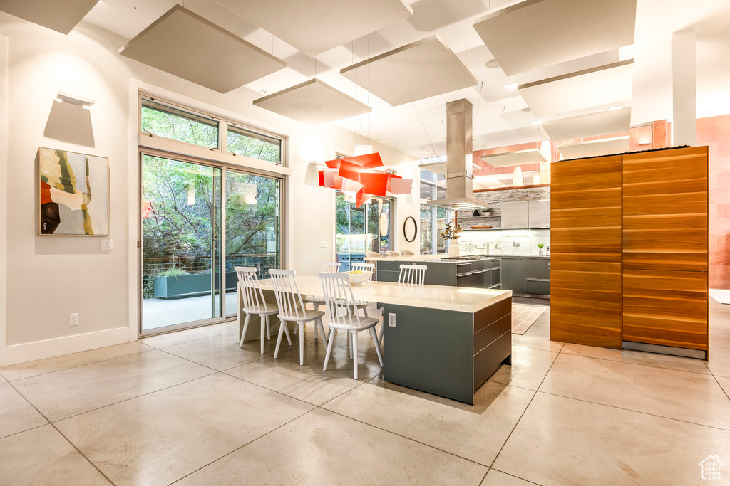 Kitchen with island range hood, light countertops, dark cabinets, modern cabinets, and open shelves