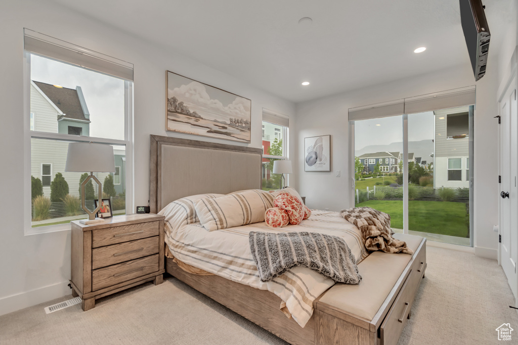 Bedroom with access to exterior, light colored carpet, and recessed lighting