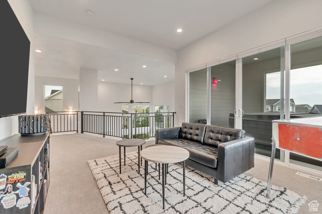 Living area with carpet, recessed lighting, and ceiling fan