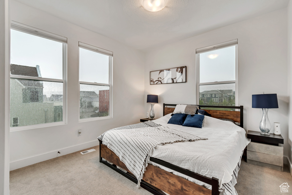 Bedroom featuring light colored carpet and baseboards